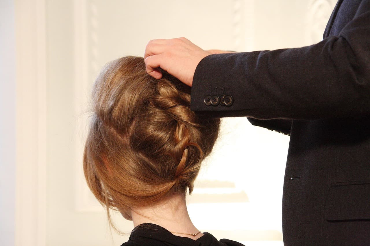 A stylist pinning an updo
