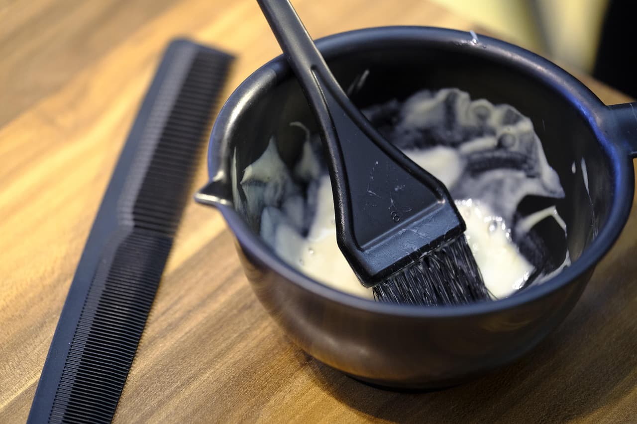 A tint bowl and brush beside a comb